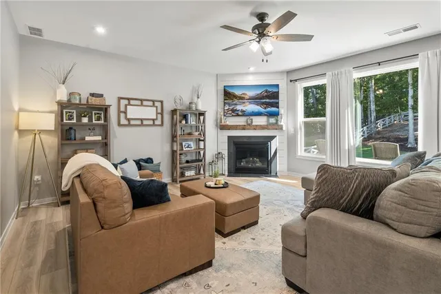 a living room with furniture a large window and a fireplace