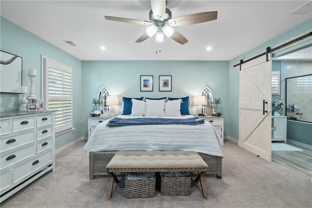 8530 Scenic Ridge Way Ball Ground, GA 30107 - Photo 17 of 45 a bedroom with a bed and a chandelier