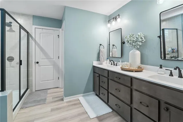 a bathroom with a double vanity sink mirror and shower