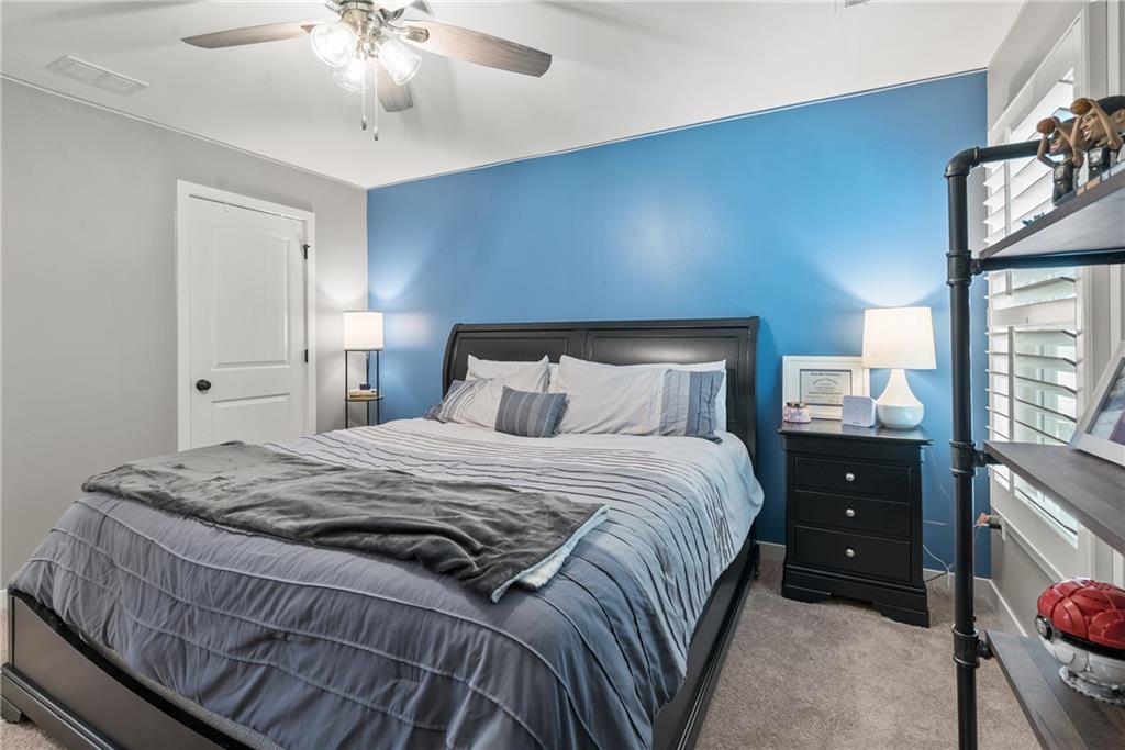 8530 Scenic Ridge Way Ball Ground, GA 30107 - Photo 26 of 45 a bedroom with a bed and a lamp