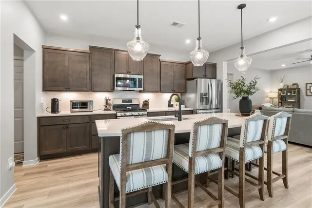 a kitchen with kitchen island granite countertop a sink and a refrigerator