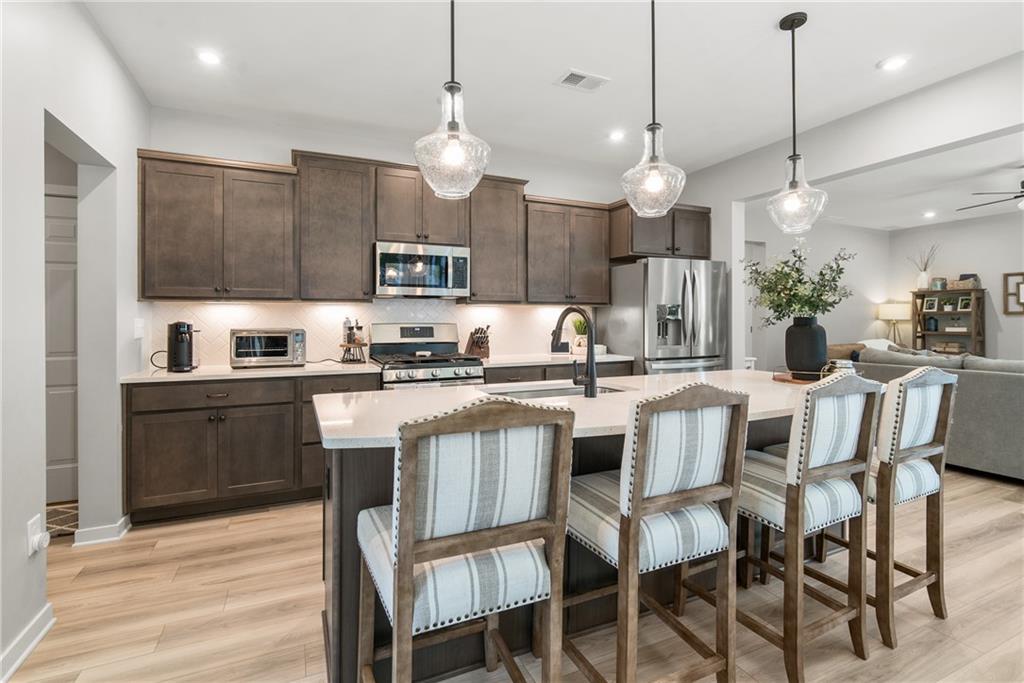 8530 Scenic Ridge Way Ball Ground, GA 30107 - Photo 3 of 45 a kitchen with kitchen island granite countertop a sink and a refrigerator