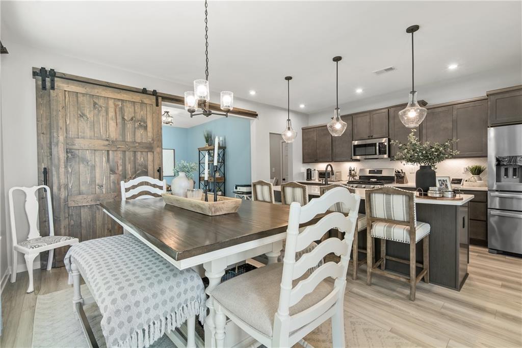 8530 Scenic Ridge Way Ball Ground, GA 30107 - Photo 6 of 45 a kitchen with kitchen island a dining table chairs stainless steel appliances and cabinets