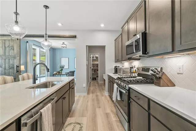 a kitchen with stainless steel appliances granite countertop a sink stove and refrigerator