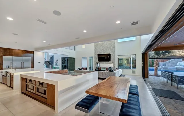 a large kitchen with kitchen island a stove a sink a dining table and chairs