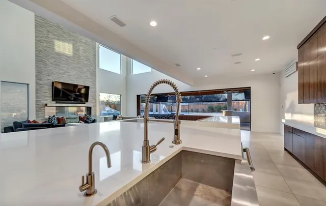 a kitchen with stainless steel appliances kitchen island granite countertop a refrigerator and a sink