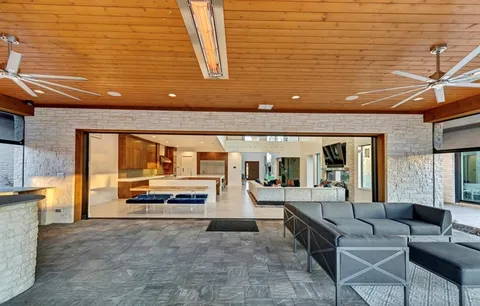 a view of a house with wooden deck and sitting area