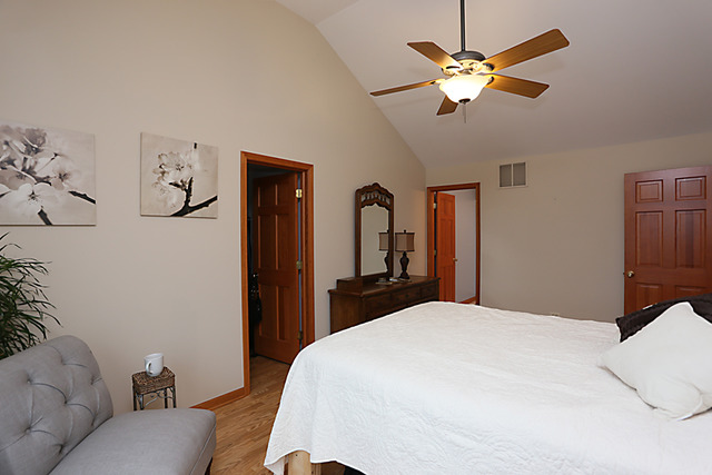 654 Ridge Drive Elburn, IL 60119 - Photo 14 of 25 a bedroom with a bed ceiling fan and a wooden floor