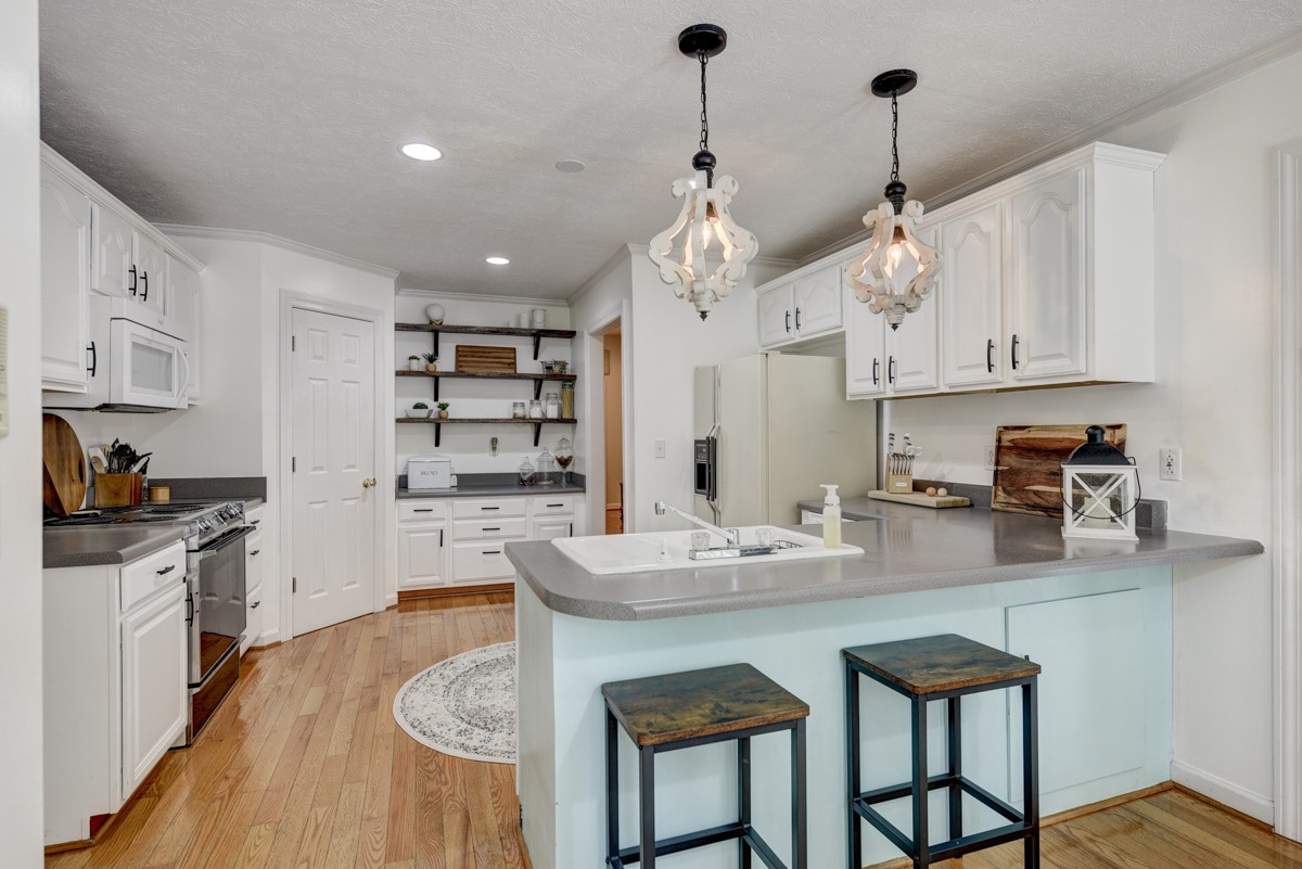 734 Keytown Road Portland, TN 37148 - Photo 12 of 49 a kitchen with stainless steel appliances granite countertop a sink a stove and chairs