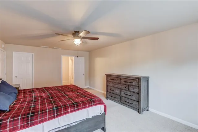 a bedroom with a bed and a ceiling fan
