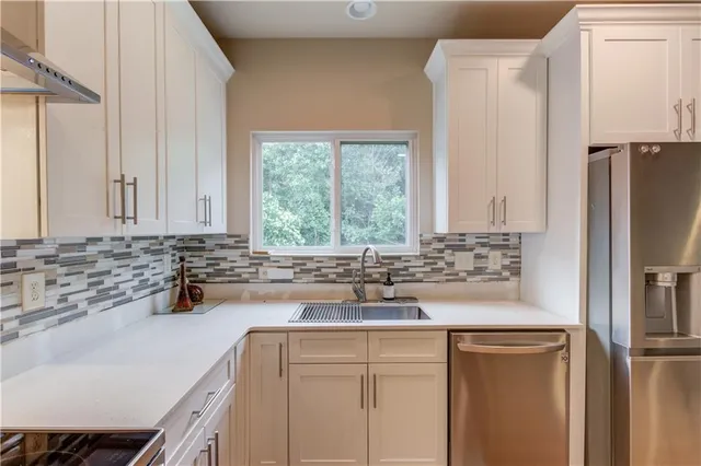 a kitchen with stainless steel appliances granite countertop a sink and a refrigerator