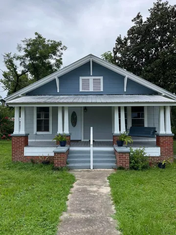 a front view of a house with a garden and plants