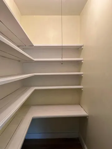 a view of walk in closet with empty racks