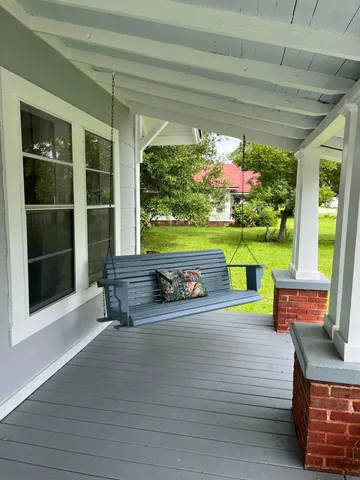 a view of a porch with furniture and garden