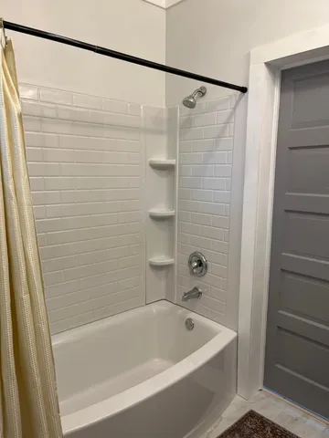 a bathroom with a shower and a bath tub