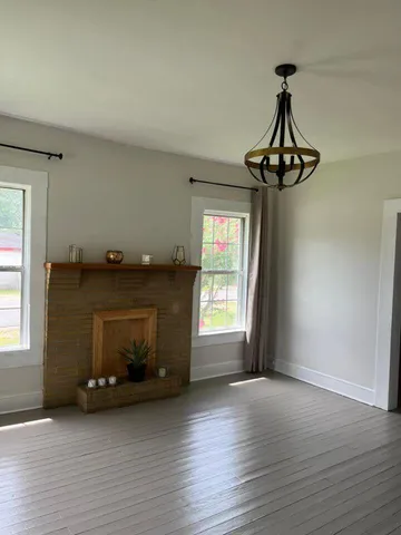 a view of a room with a window and wooden floor