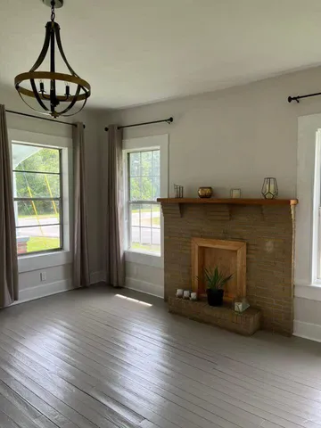 a living room with hardwood floor and a window