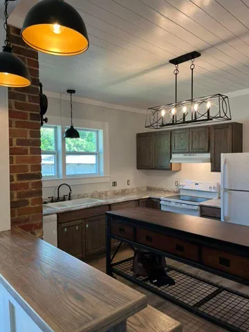 a kitchen with stainless steel appliances granite countertop a sink and a stove