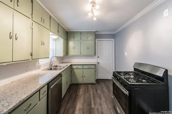 a kitchen with a sink stove and cabinets
