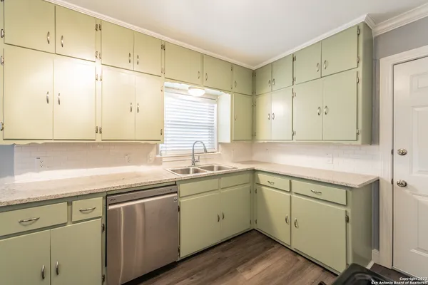a kitchen with a sink cabinets and wooden floor