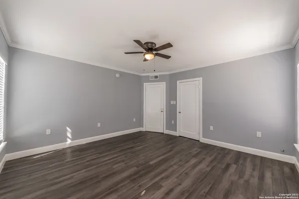 a view of a room with wooden floor and a ceiling fan