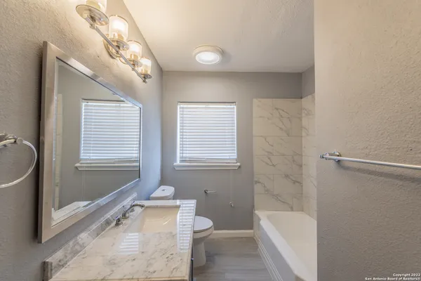 a bathroom with a tub a window and a shower