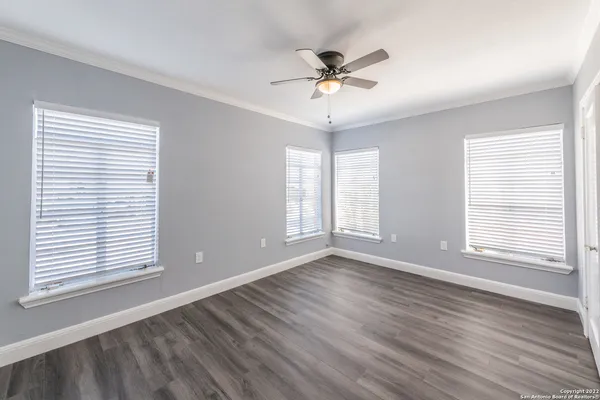 a view of an empty room with a window and wooden floor
