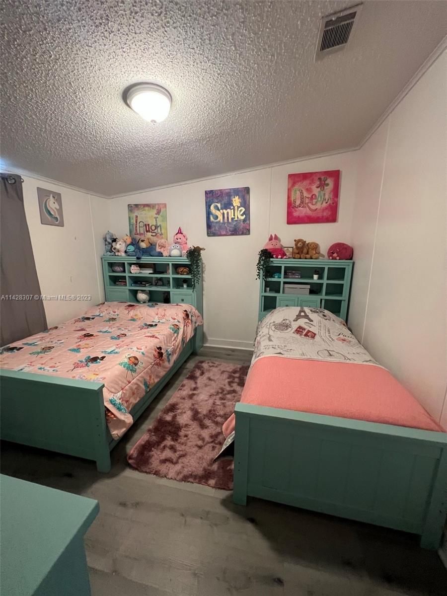 Gateway Estates Park Homestead, FL 33034 - Photo 19 of 26 a bedroom with a bed and a dresser