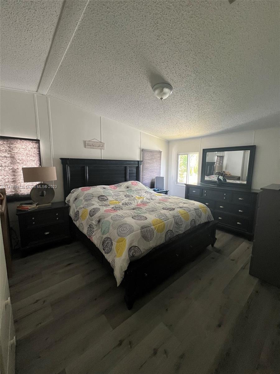 Gateway Estates Park Homestead, FL 33034 - Photo 23 of 26 a bedroom with a bed and wooden floor