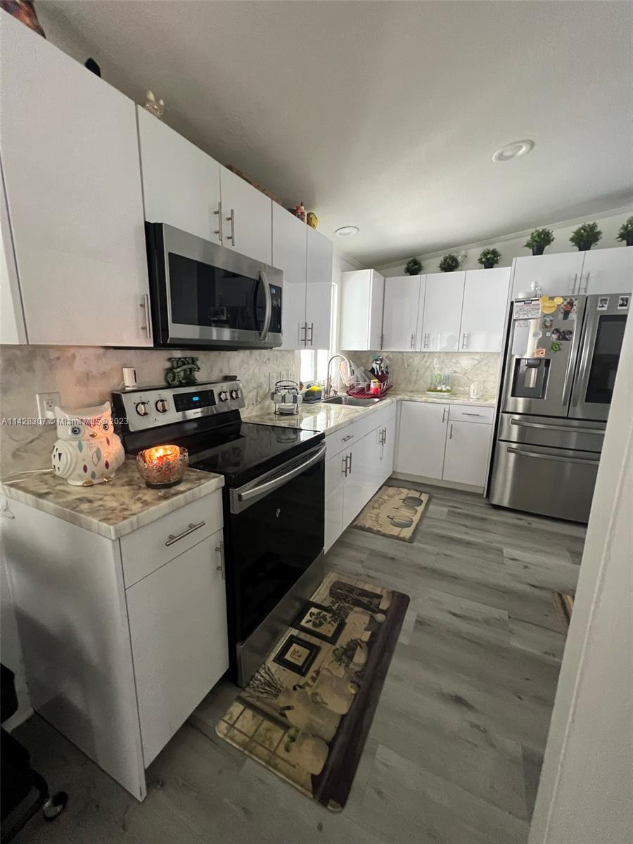 Gateway Estates Park Homestead, FL 33034 - Photo 5 of 26 a kitchen with a sink stove and microwave
