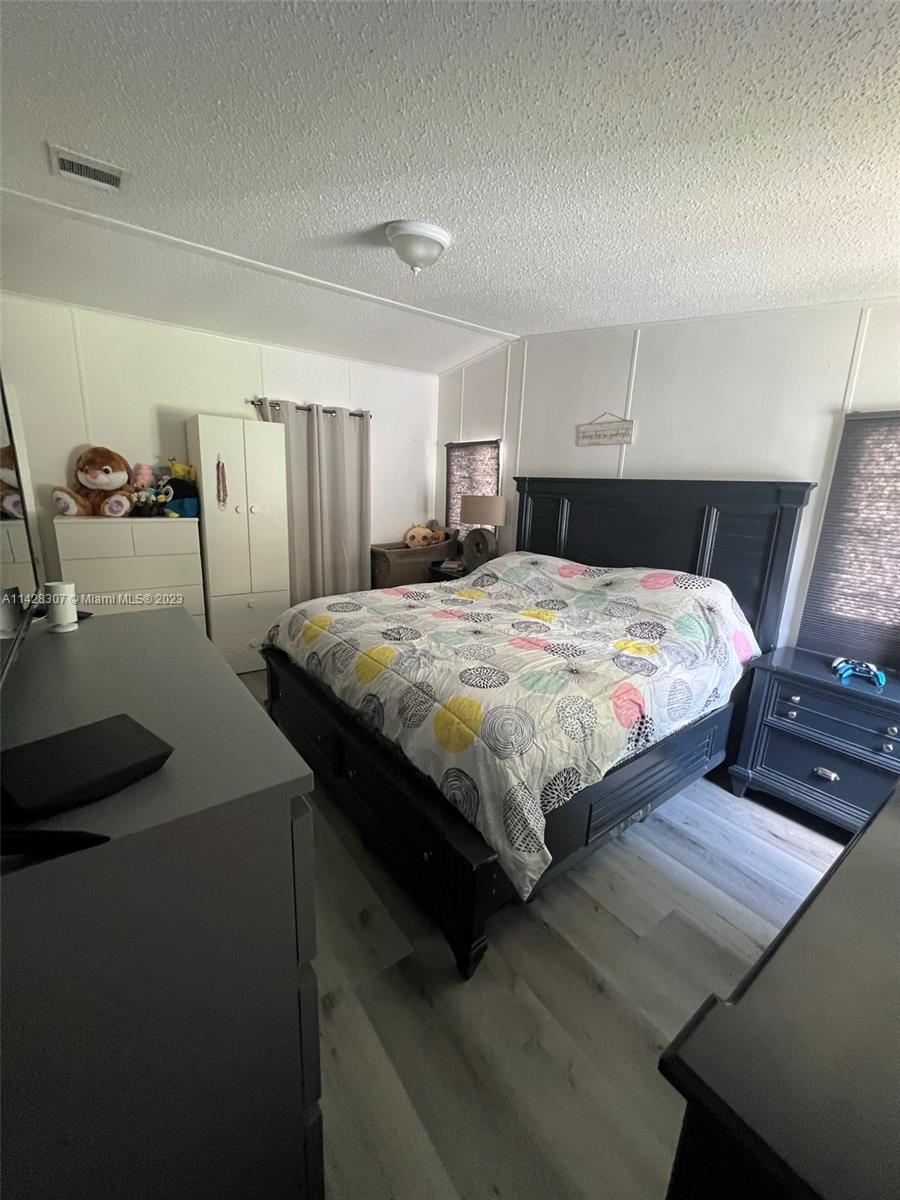 Gateway Estates Park Homestead, FL 33034 - Photo 9 of 26 a bedroom with a bed and wooden floor