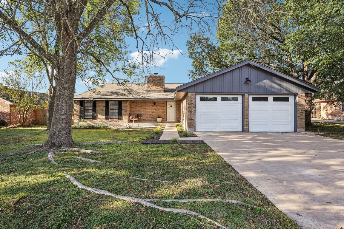 5307 Beckett Circle Austin, TX 78749 - Photo 2 of 29 View of front of property featuring brick siding, concrete driveway, a chimney, a front lawn, and an attached garage