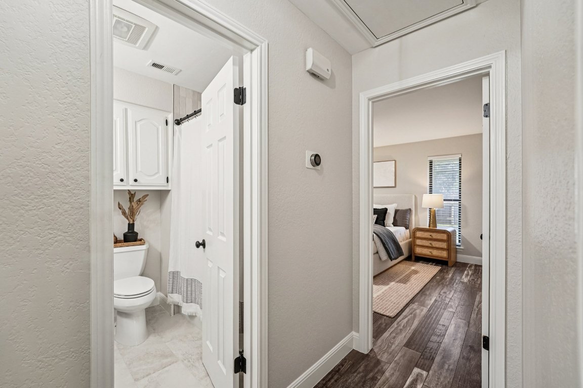 5307 Beckett Circle Austin, TX 78749 - Photo 21 of 29 Ensuite bathroom with a shower with shower curtain, a textured wall, and dark wood finished floors