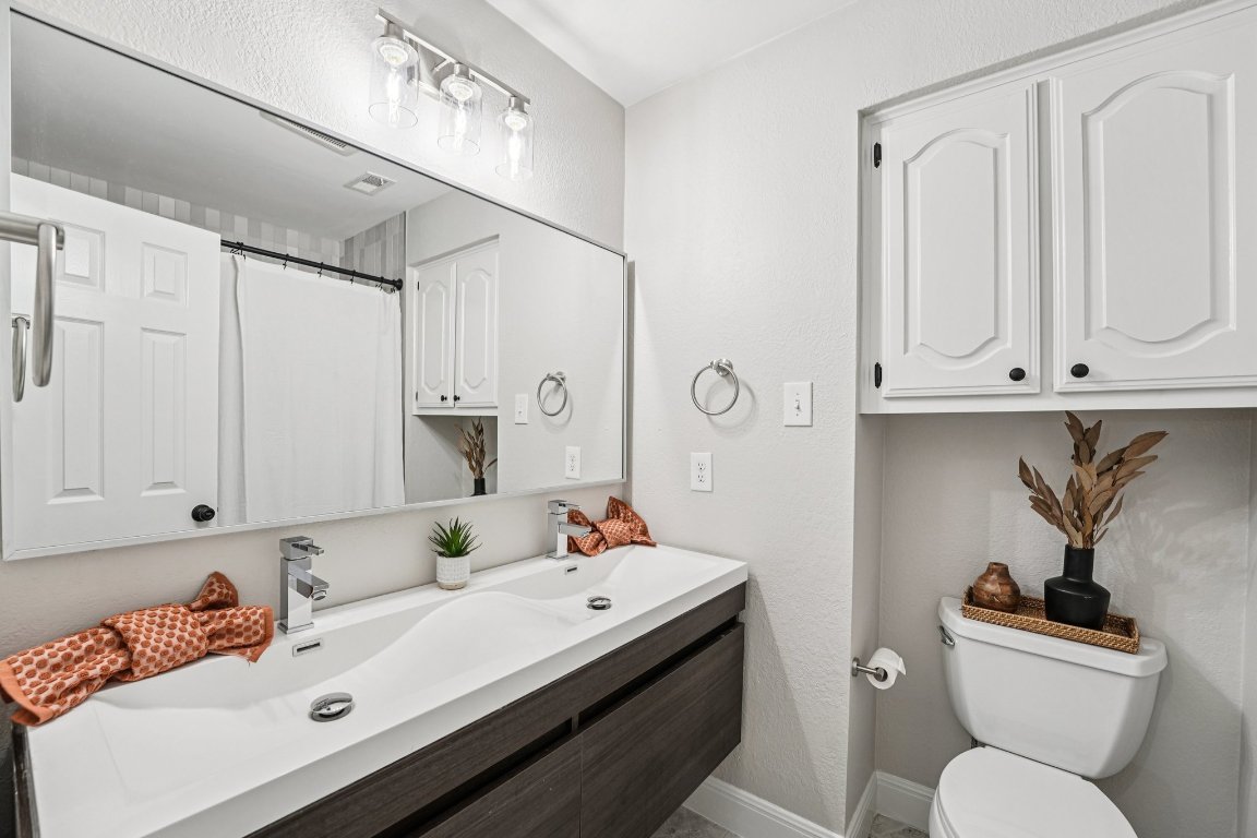 5307 Beckett Circle Austin, TX 78749 - Photo 24 of 29 Full bath featuring double vanity, a textured wall, and a shower with shower curtain