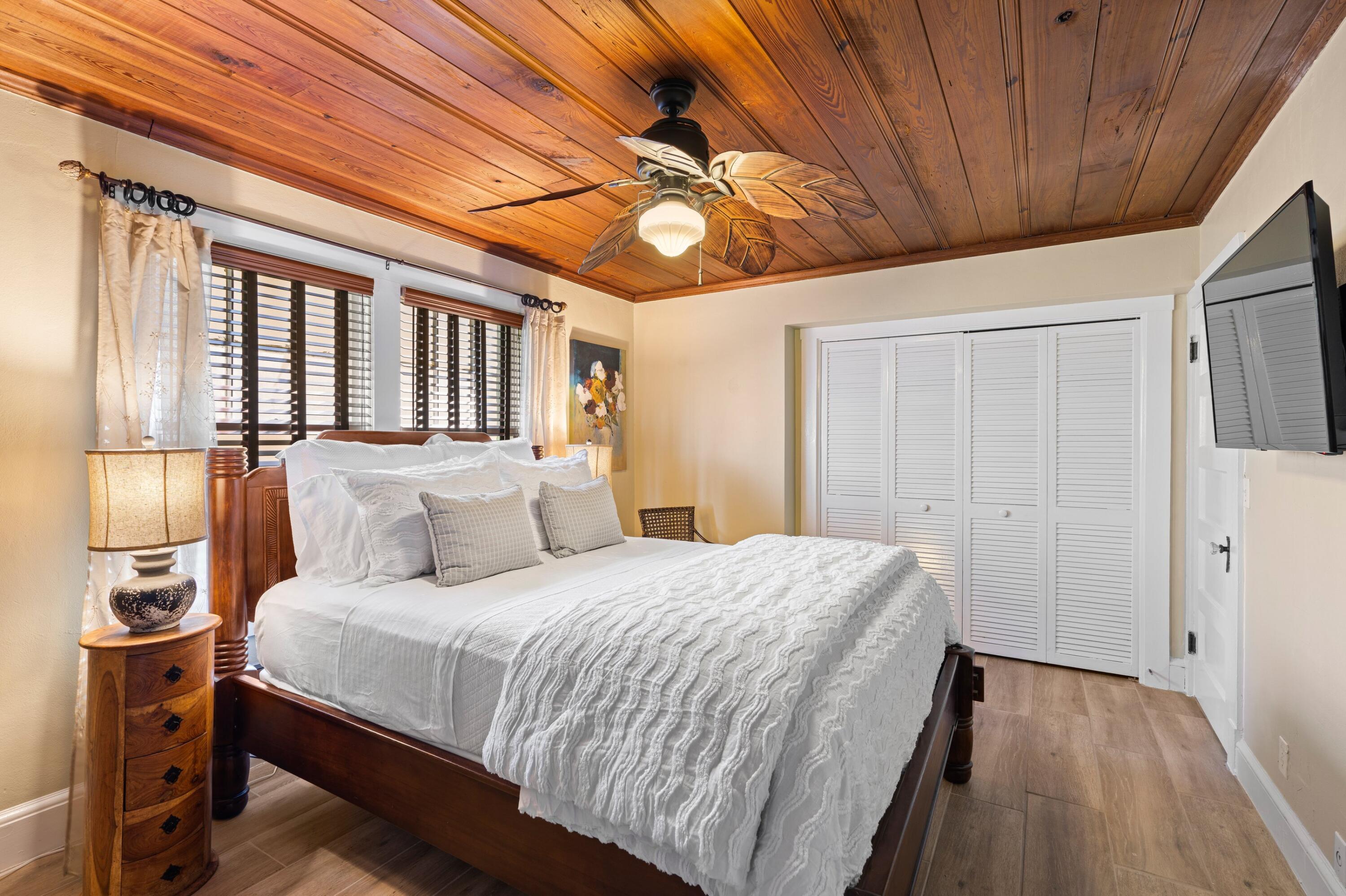 102 Southeast 7th Avenue, Unit VILLA 4 Delray Beach, FL 33483 - Photo 15 of 23 a bedroom with a large bed and a chandelier