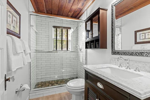 a bathroom with a granite countertop sink toilet and shower