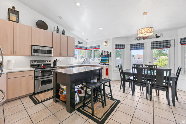 31 Village Square Road Centerville, UT 84014 - Photo 12 of 29 Spacious kitchen featuring light-toned cabinetry, stainless steel appliances, and a central island with an integrated breakfast bar
