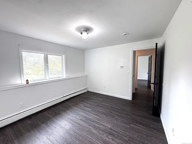 an empty room with wooden floor and a window