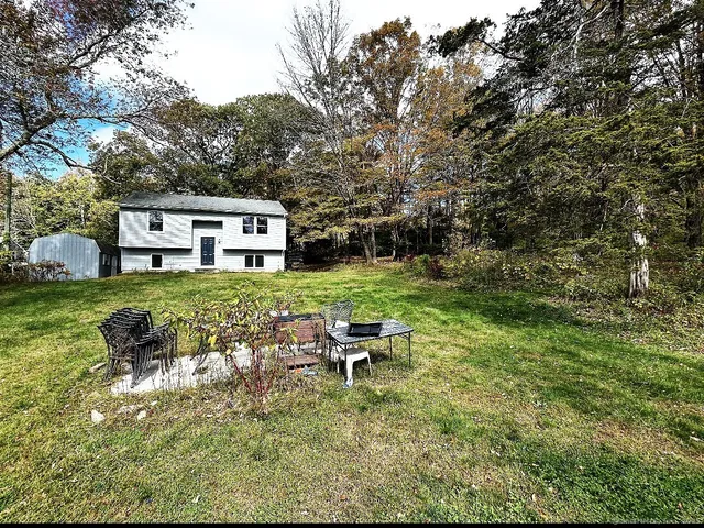 a backyard of a house with table and chairs