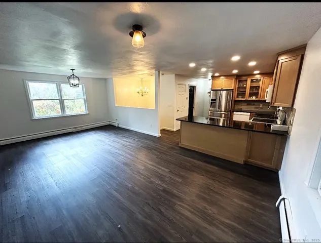 a view of a living room and kitchen with wooden floor