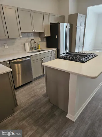 a kitchen with granite countertop a sink stainless steel appliances and cabinets