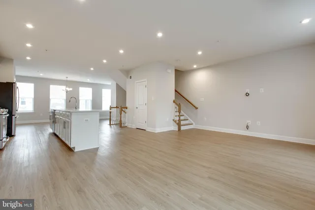 a view of a big room with wooden floor and a kitchen