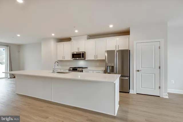 a kitchen with stainless steel appliances a refrigerator sink and microwave