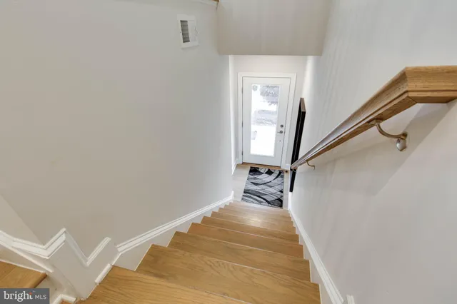 a view of a hallway with wooden floor and staircase
