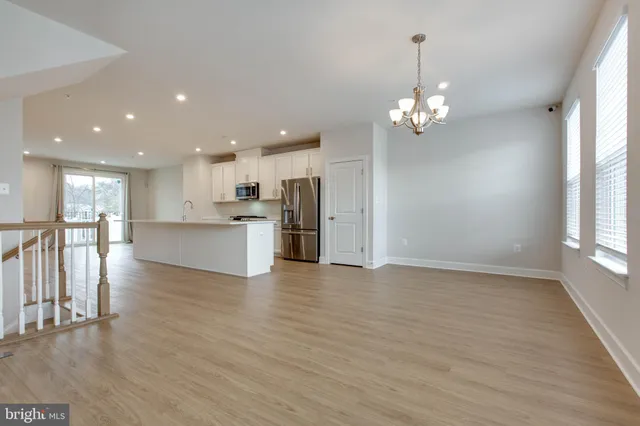 a view of a kitchen with a sink a refrigerator and a chandelier