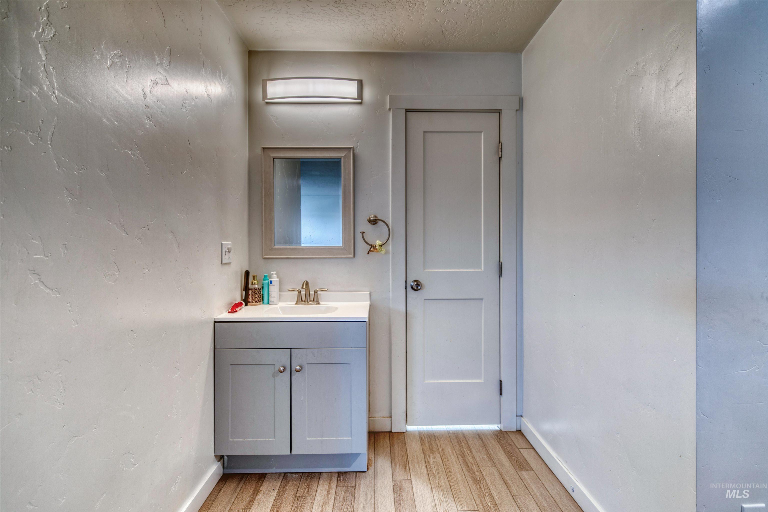 112 East Main Street Nyssa, OR 97913 - Photo 22 of 43 Bathroom with vanity, wood finished floors, and a textured ceiling