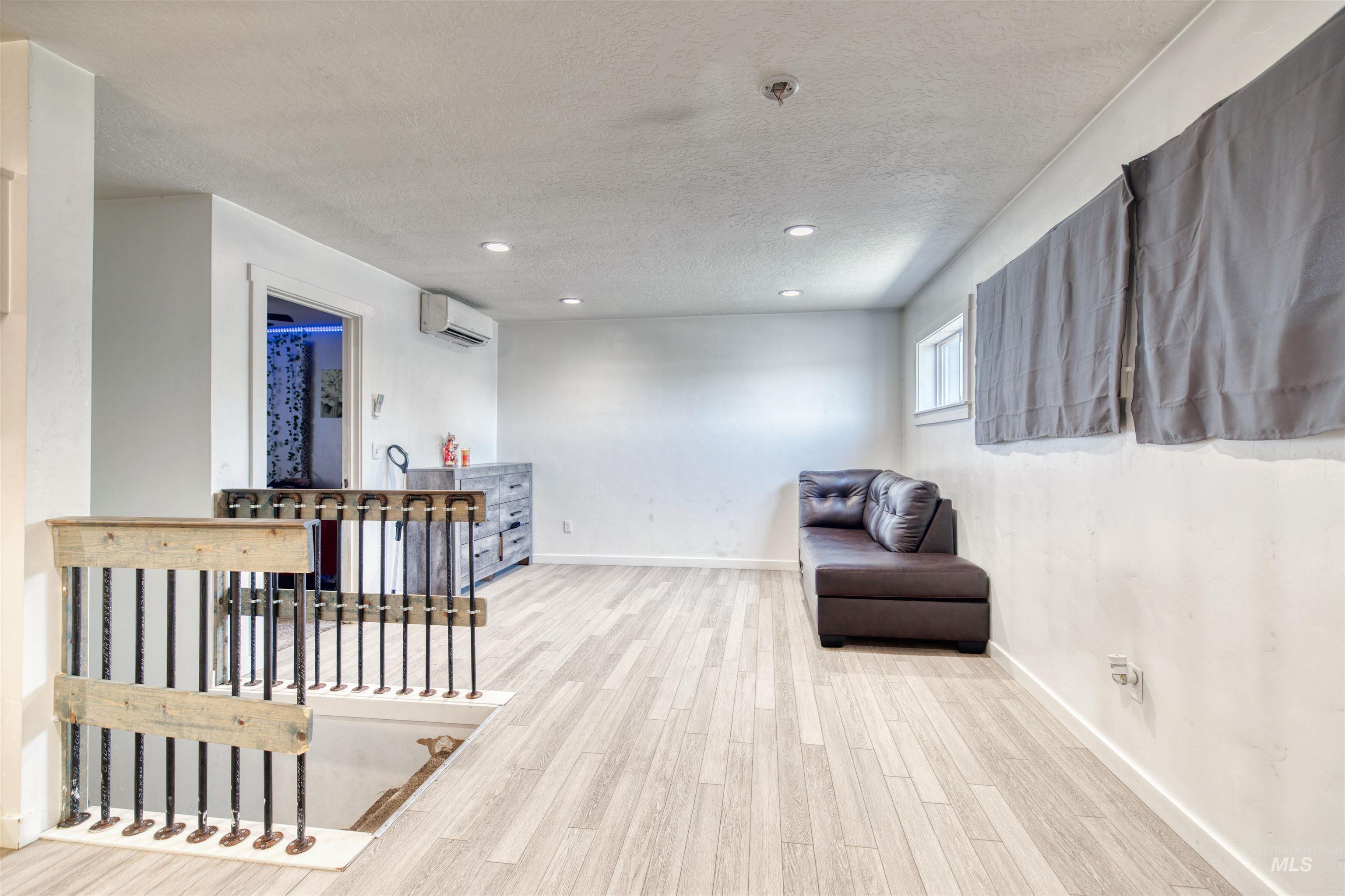 112 East Main Street Nyssa, OR 97913 - Photo 23 of 43 Living area with wood finished floors, a textured ceiling, recessed lighting, an upstairs landing, and a wall mounted AC