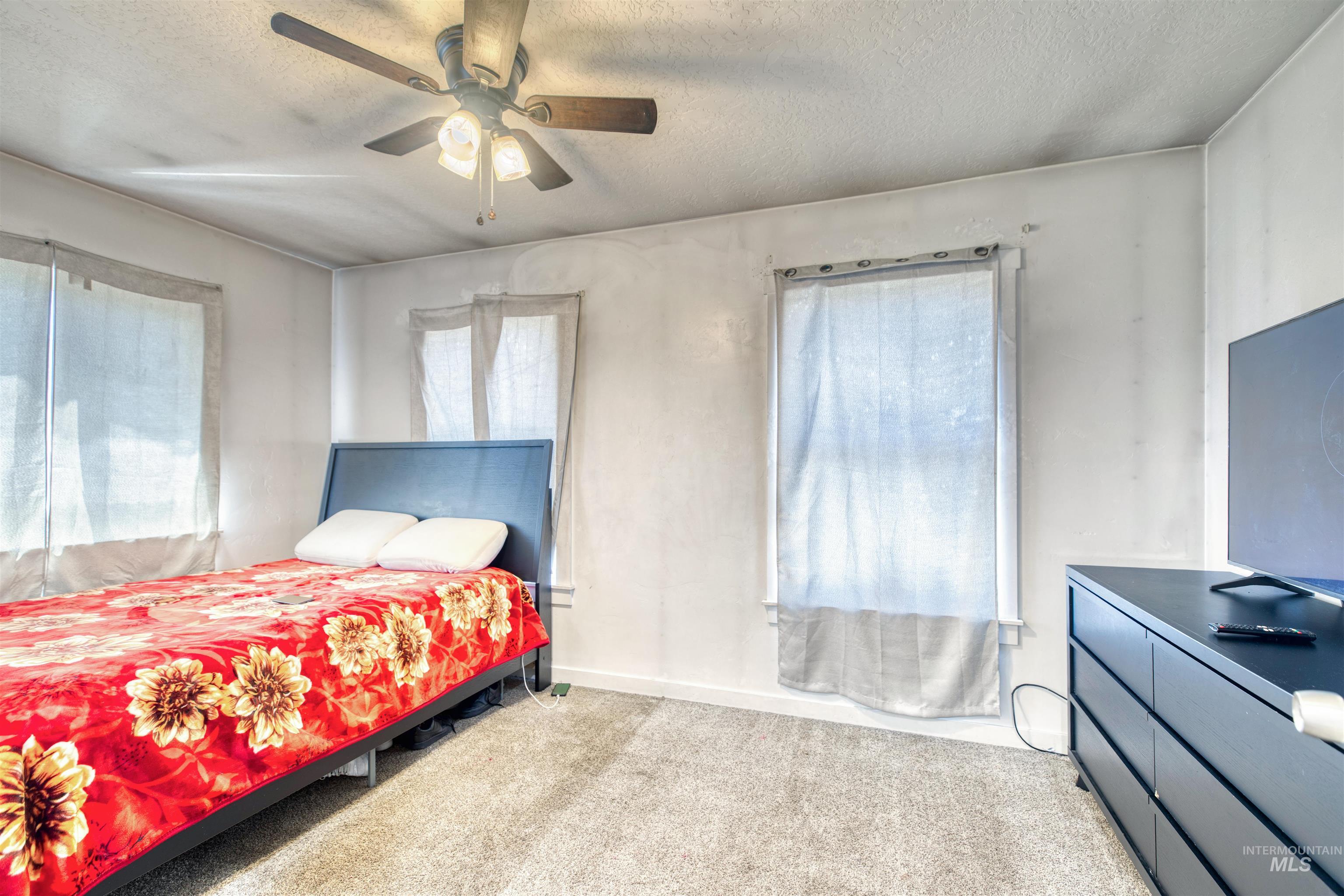 112 East Main Street Nyssa, OR 97913 - Photo 28 of 43 Carpeted bedroom featuring a textured ceiling and ceiling fan