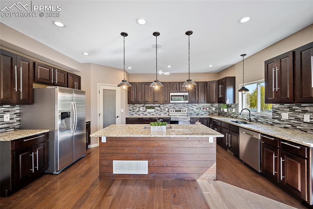 633 Tierra Verde Court Colorado Springs, CO 80904 - Photo 16 of 50 a large kitchen with stainless steel appliances granite countertop a stove and a refrigerator