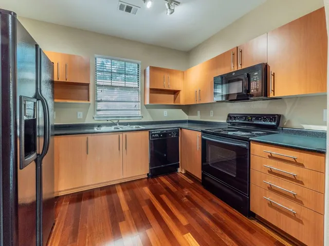 a kitchen with stainless steel appliances granite countertop a stove a sink and a refrigerator